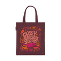 A dark burgundy tote with "Cozy Reading Season" in large letter surrounded by leaves, an open pink book, and a yellow cup of coffee against a white background.