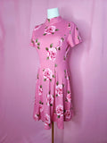 Dress on a white mannequin against a light pink background.