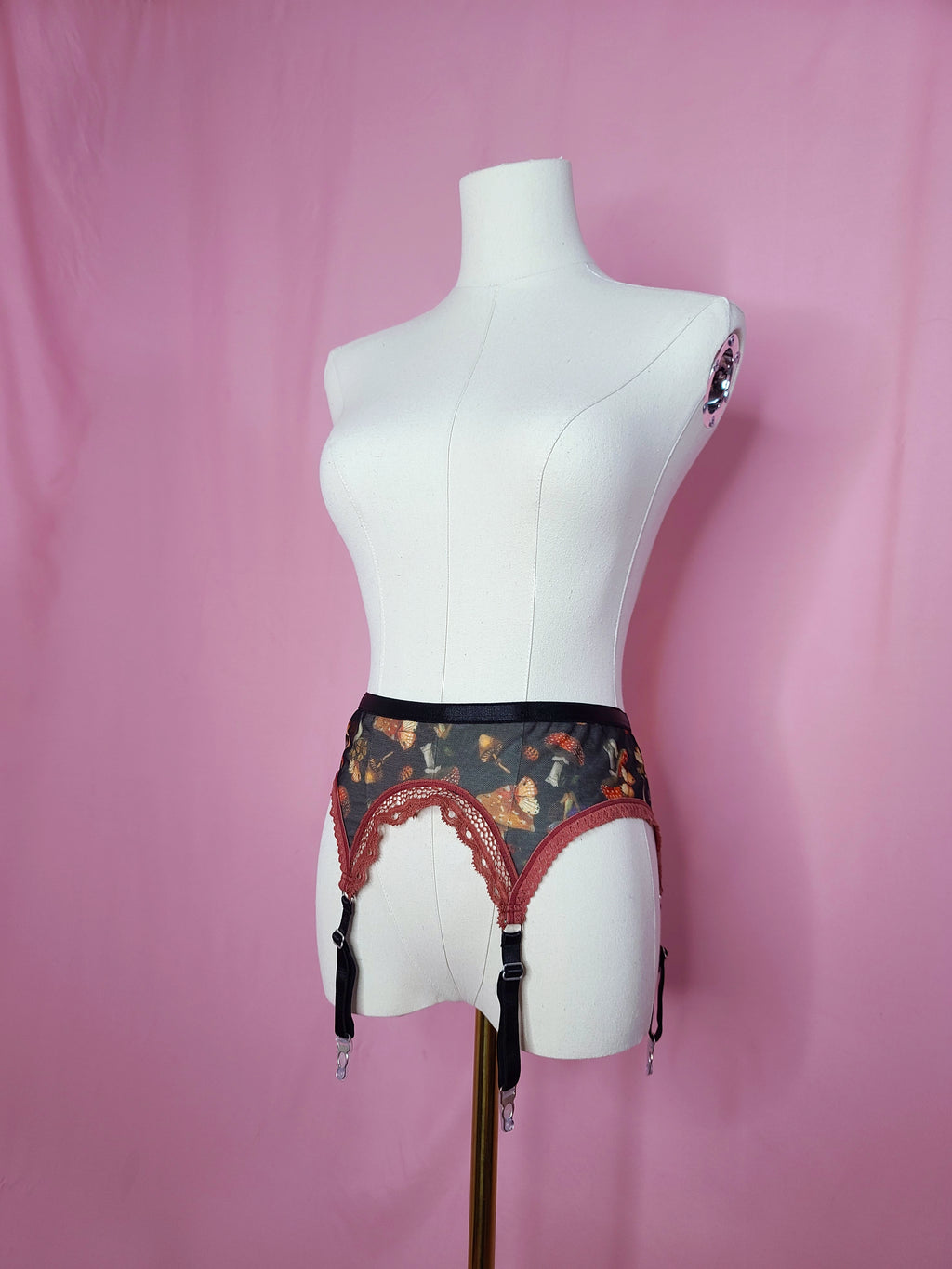 Garter on a white mannequin against a pink background