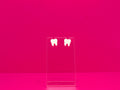 Pair of white tooth earrings on a clear display against a hot pink background.