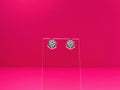 D20 dice earrings on a clear display against a pink background.