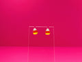 Candy corn earrings on a clear display against a pink background.