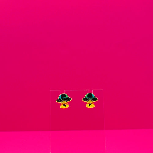 UFO abducting cows on a clear stand against a pink background.