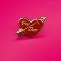 Heart-shaped pin with 'They' and 'Them' text on a pink background.