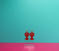 Red marbled lobster earrings on a clear display against a blue and pink background.