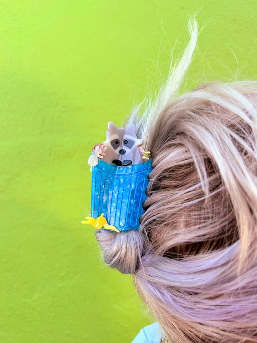 Hair claw worn by a hair model with light blonde hair against a bright green background.