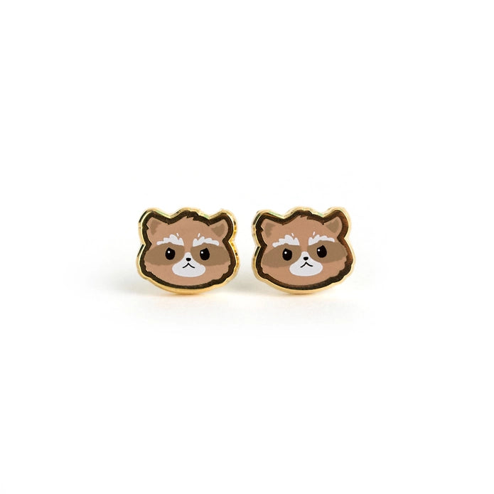 Pair of raccoon head earrings against a white background.