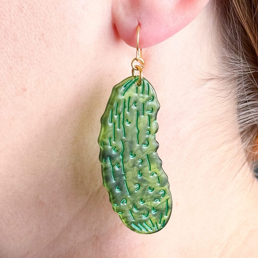 Green pickle earring shown on a model's ear.