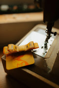 Yellow measuring tape hair bow on a vintage sewing machine.