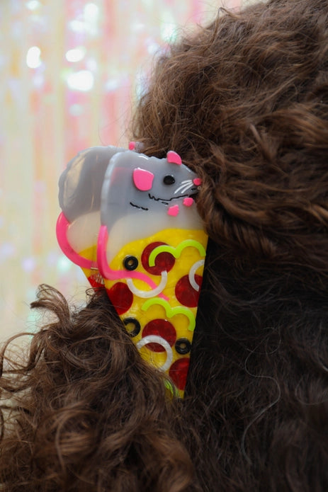 Pizza rat hair claw in brown, curly hair against a light background.