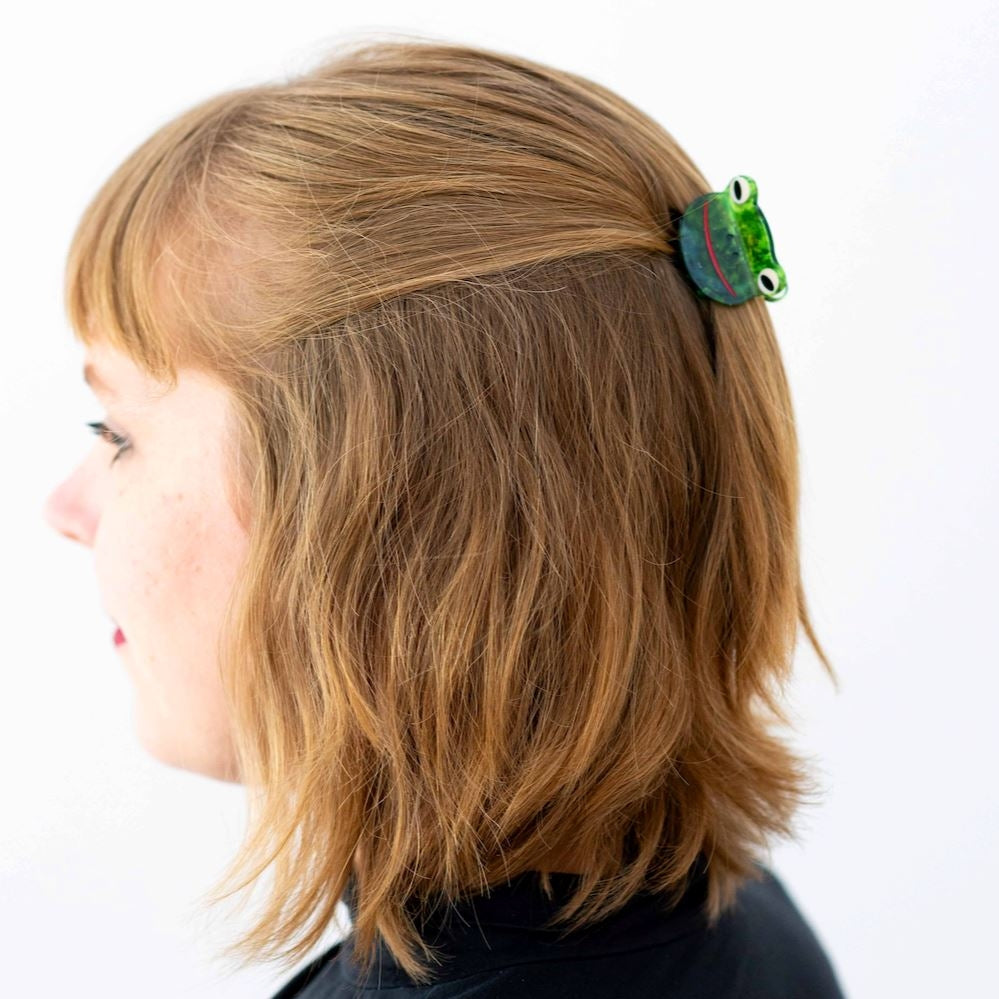 Hair claw in use on a brunette model with short hair against a white background.