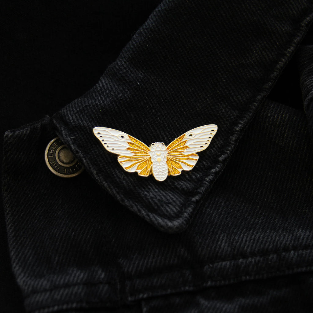 Pin shown on a black denim jacket collar