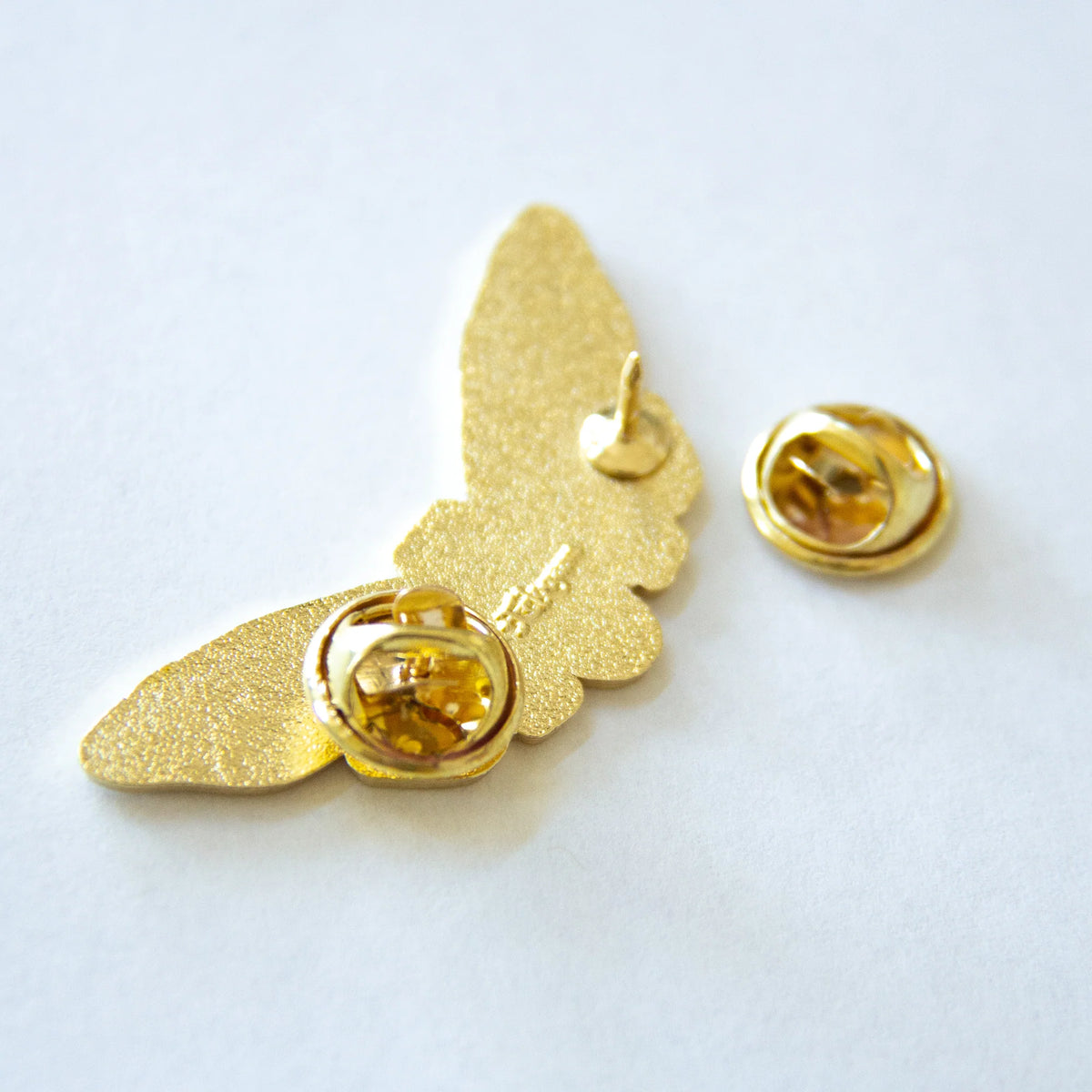Back of pin against a white background. Back shows the 2 points that keep the pin from spinning